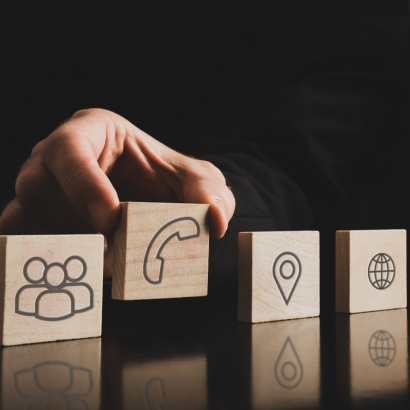 Бизнесмен държи кубче с телефон.  