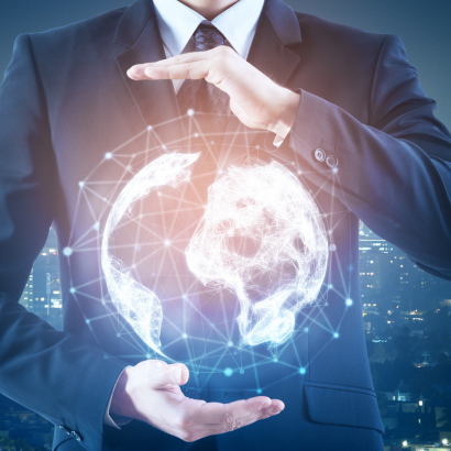 Мъж в бизнес костюм, държащ дигитално холограмно изображение на Земята на фона на градски пейзаж през нощта.